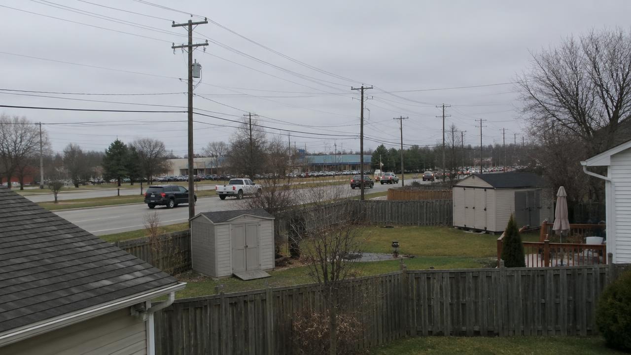 Busy road and power lines behind suburban backyards, external factors that can lower value