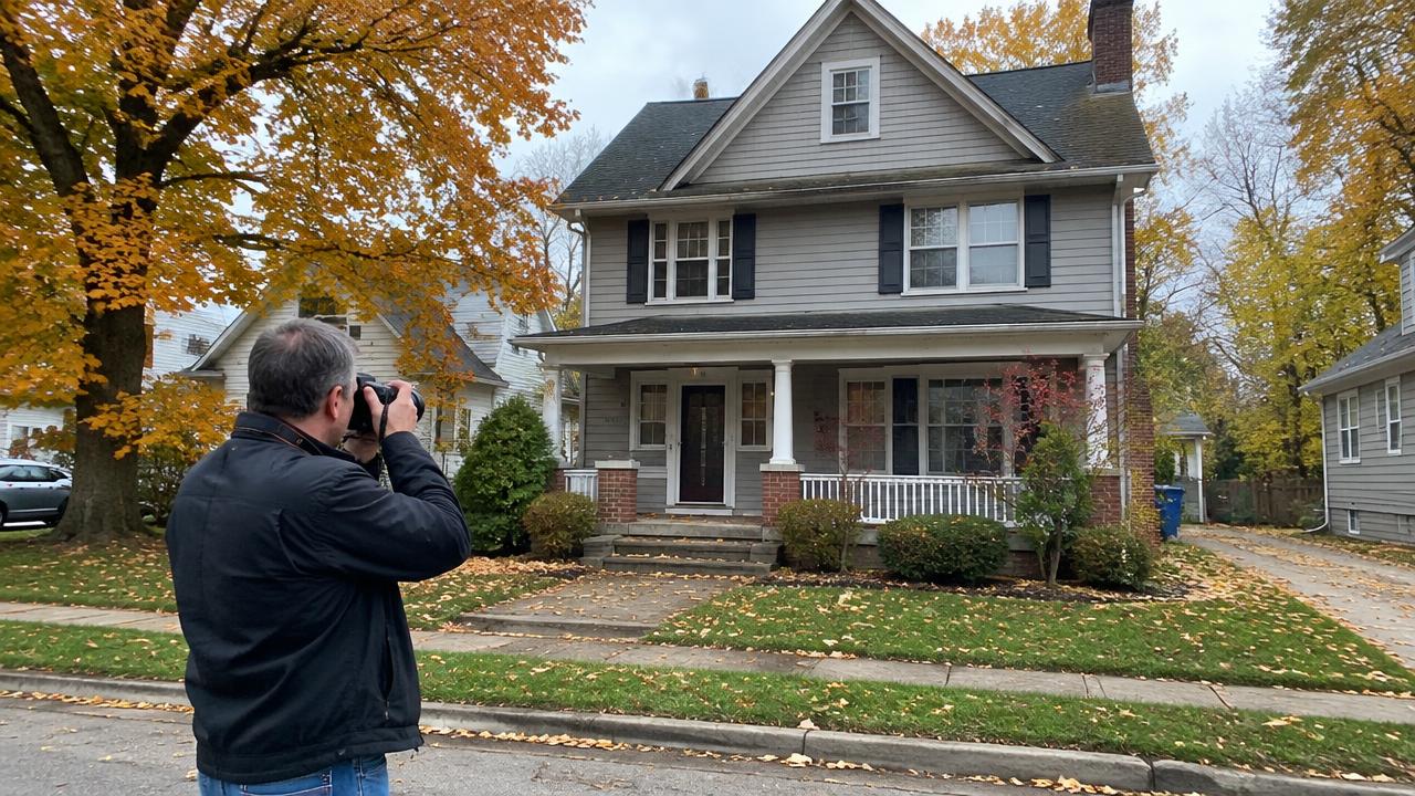 Appraiser photographing the exterior of a Michigan home during an in-person inspection